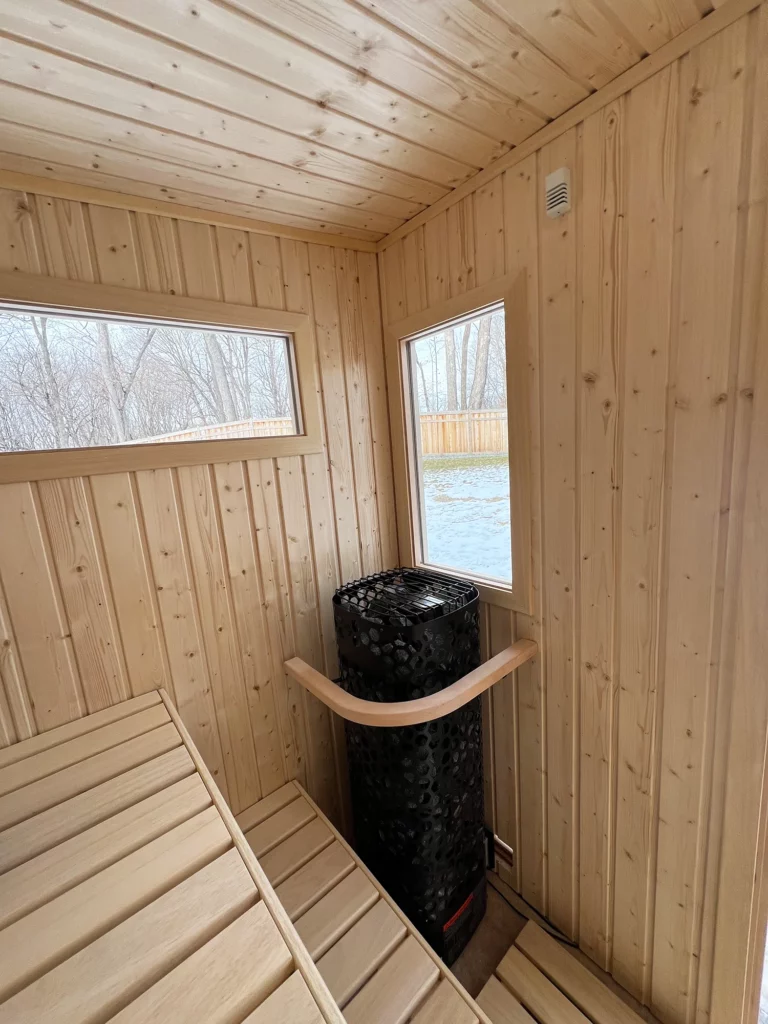 nordic spruce sauna interior with finnleo himalaya rock tower heater