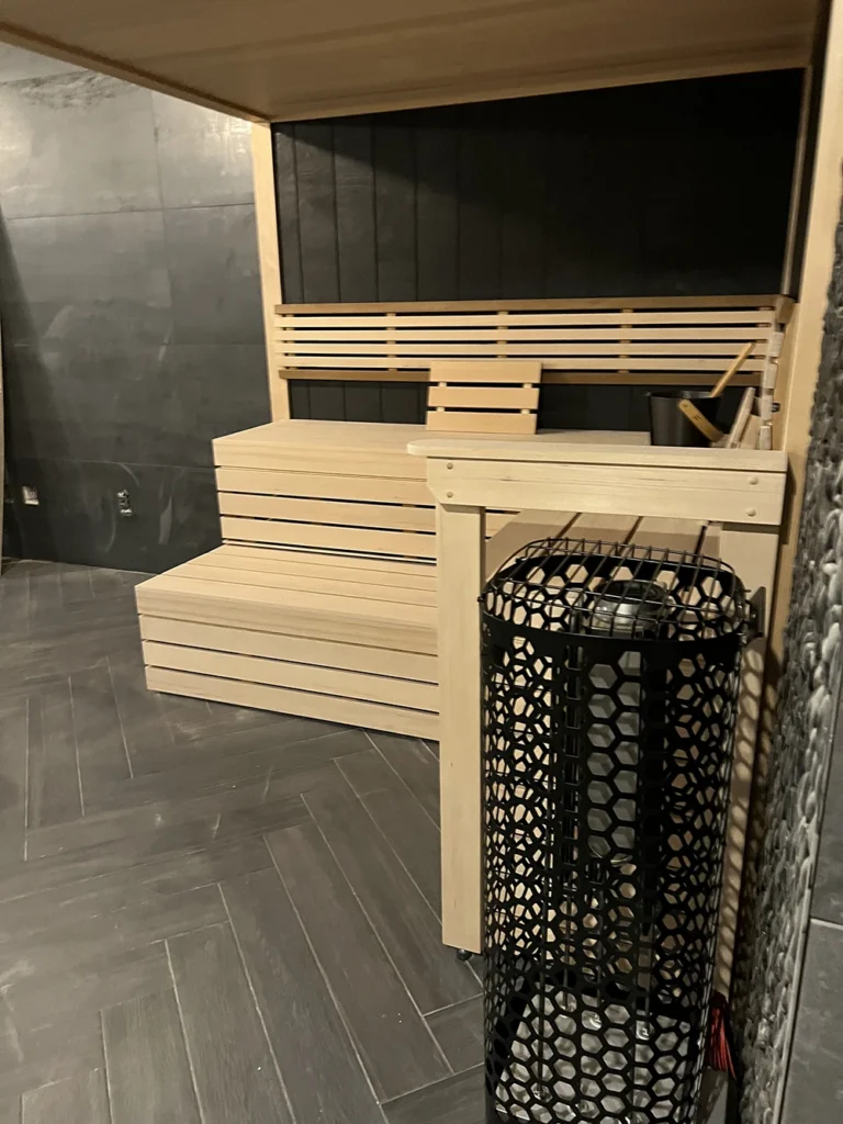 a custom black taika sauna with all glass front