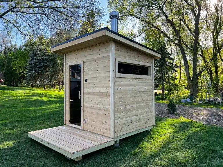 side angle of custom knotty cedar sauna with bronze tint horizontal window