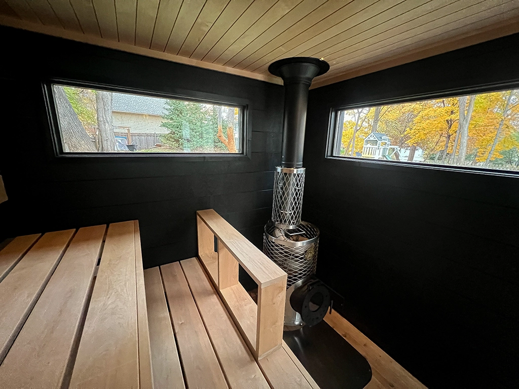 black taika sauna interior with iki wood fired stove