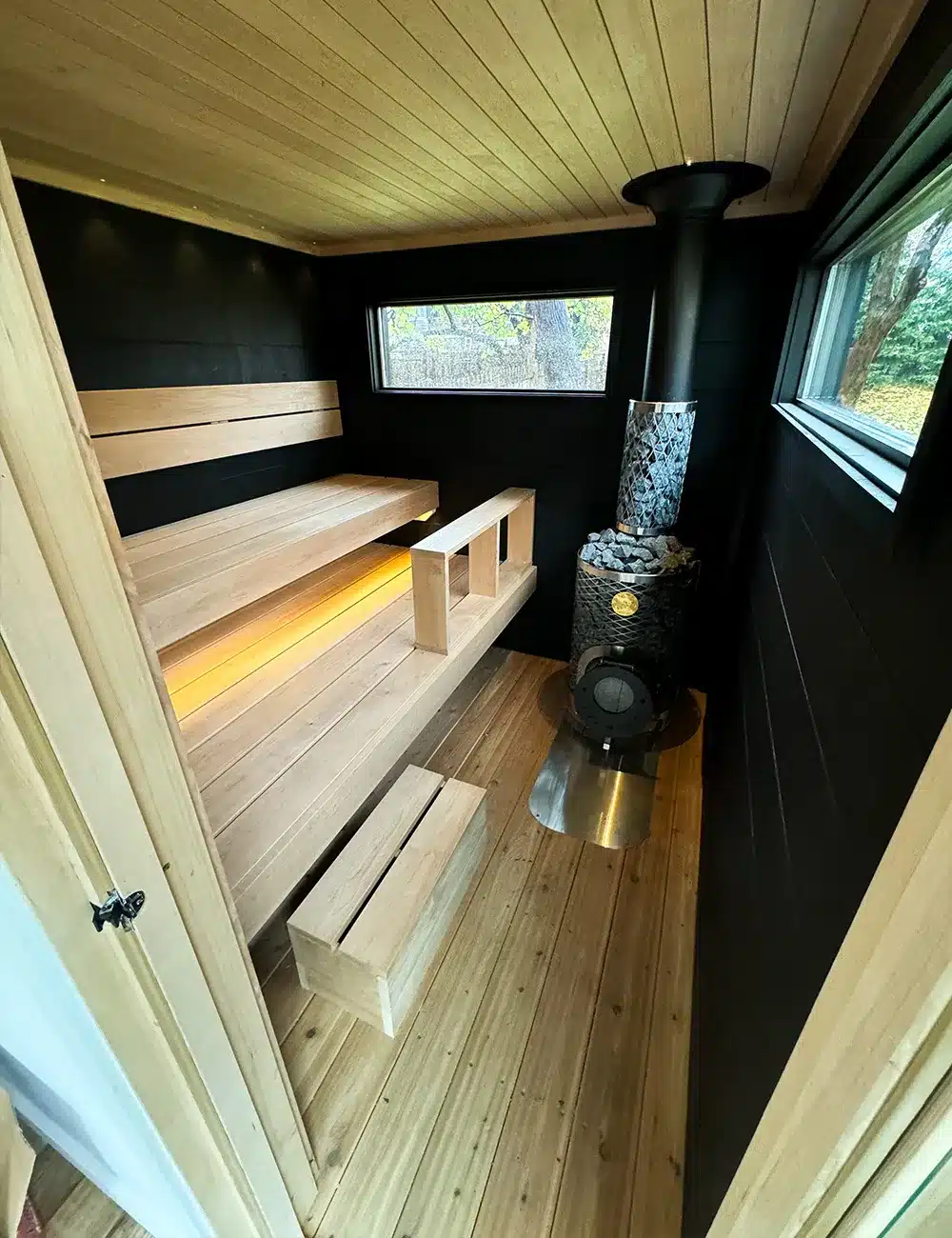 8x12 black taika outdoor sauna with lights on