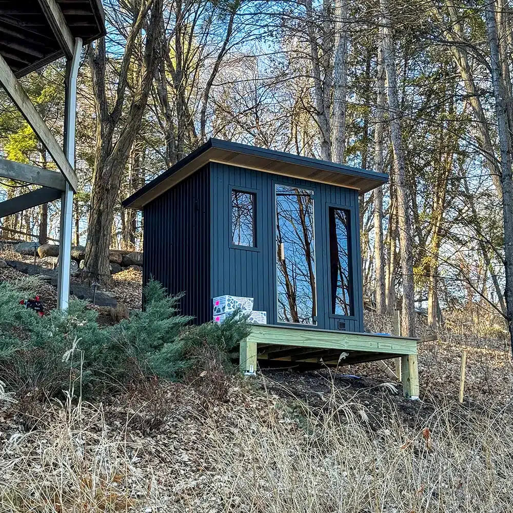 black painted 6x8 custom euro sauna on deck in the woods