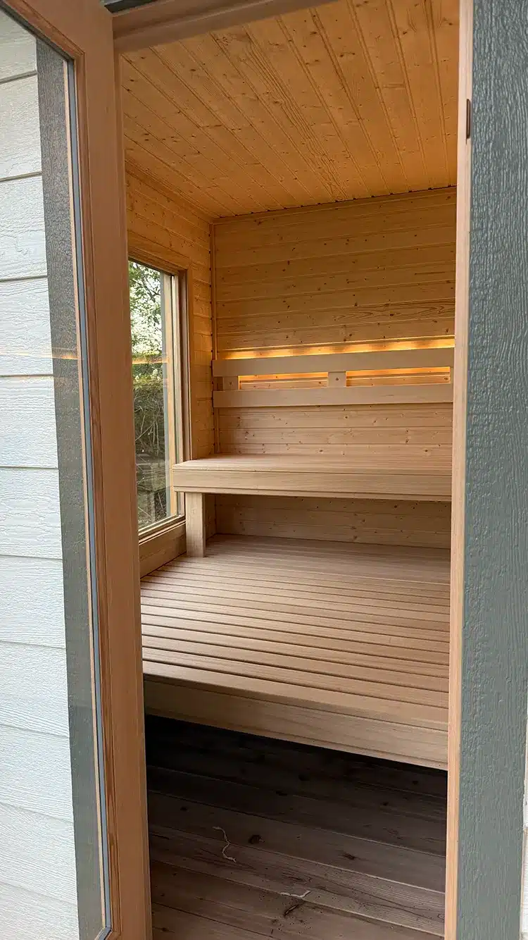 nordic spruce and aspen interior on custom outdoor sauna with big glass window