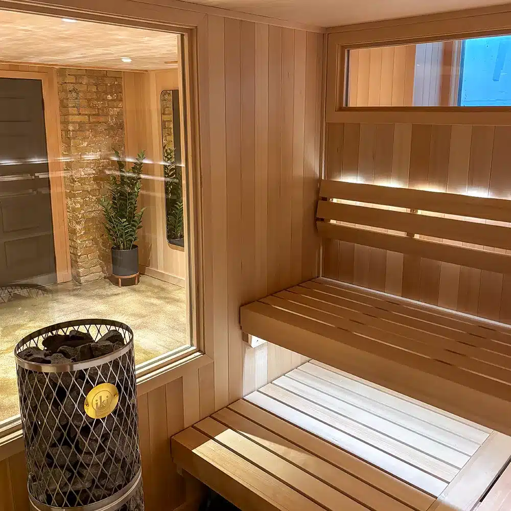 iki pillar heater, clear glass window and curved 3 bar backrest in custom indoor traditional sauna in minnesota